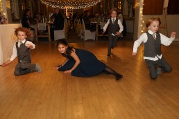 Four children sliding on the dance floor at a wedding reception at Addington Palace Golf Club