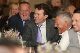 Wedding guests smiling and laughing at the speeches at Addington Palace Golf Club